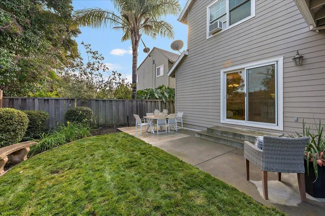 a view of a chair and table in backyard of the house
