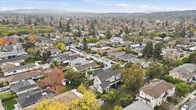 an aerial view of residential house with parking and mountain view
