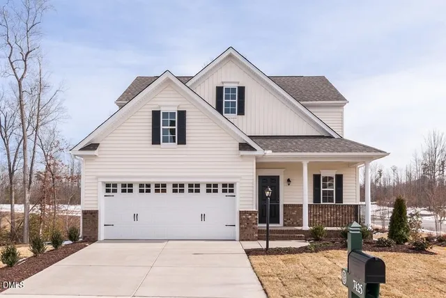 a view of a house with a yard and potted plants
