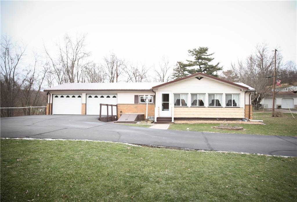 411 Reservoir Road Dunbar, PA 15431 - Photo 1 of 18 a front view of a house with a yard and garage