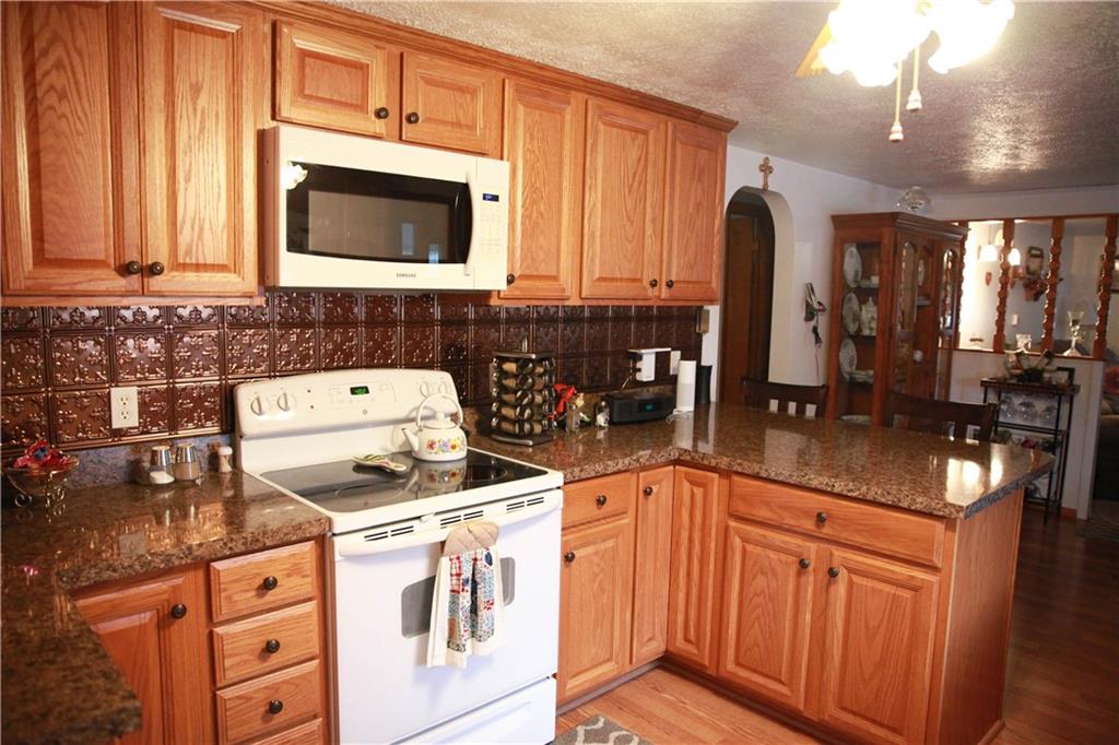 411 Reservoir Road Dunbar, PA 15431 - Photo 7 of 18 a kitchen with stainless steel appliances granite countertop a stove a sink and a microwave