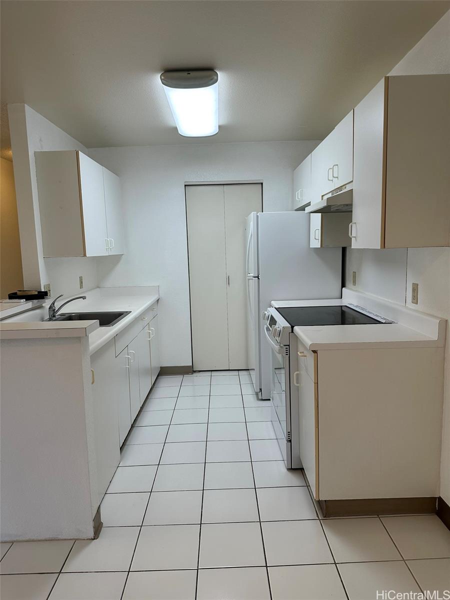 94-209 Lumiaina Place, Unit J203 Waipahu, HI 96797 - Photo 3 of 19 a kitchen with a sink a stove and a refrigerator