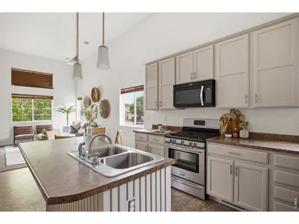 a kitchen with kitchen island a sink a stove and microwave