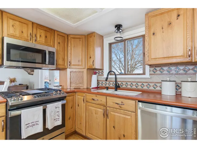 a kitchen with stainless steel appliances granite countertop a sink stove and microwave