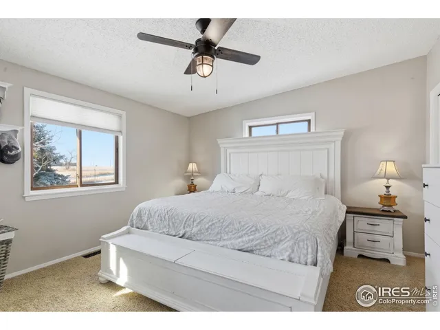 a bedroom with a bed a couch and a painting on the wall