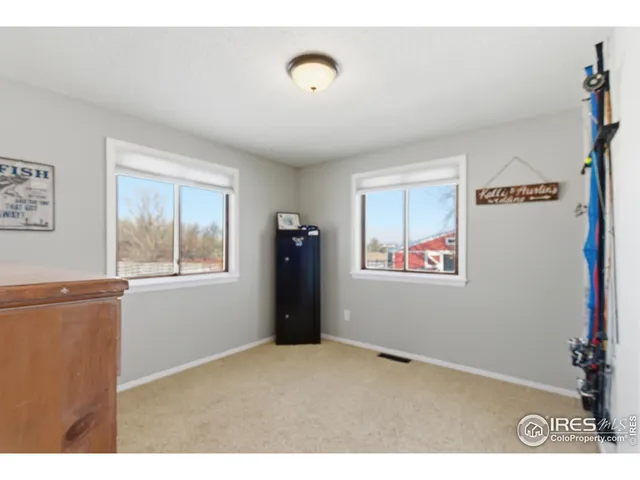 a view of an empty room with window and cabinet