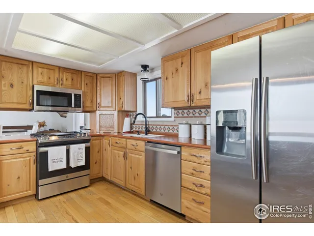 a kitchen with stainless steel appliances granite countertop a refrigerator a stove top oven a sink and dishwasher