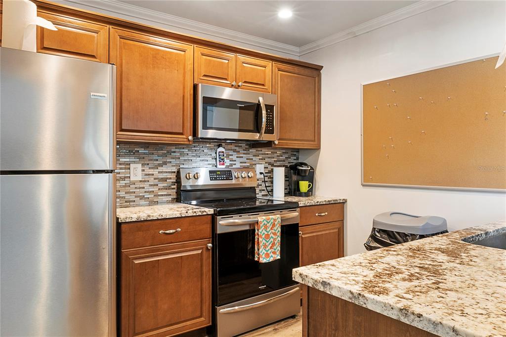 3273 South Beneva Road, Unit 203 Sarasota, FL 34232 - Photo 27 of 36 a kitchen with stainless steel appliances granite countertop a sink stove and refrigerator