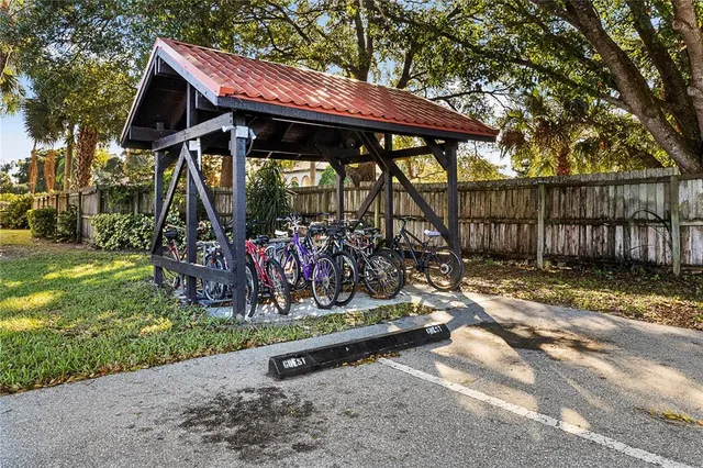 a sign that is sitting in front of a house with a tree