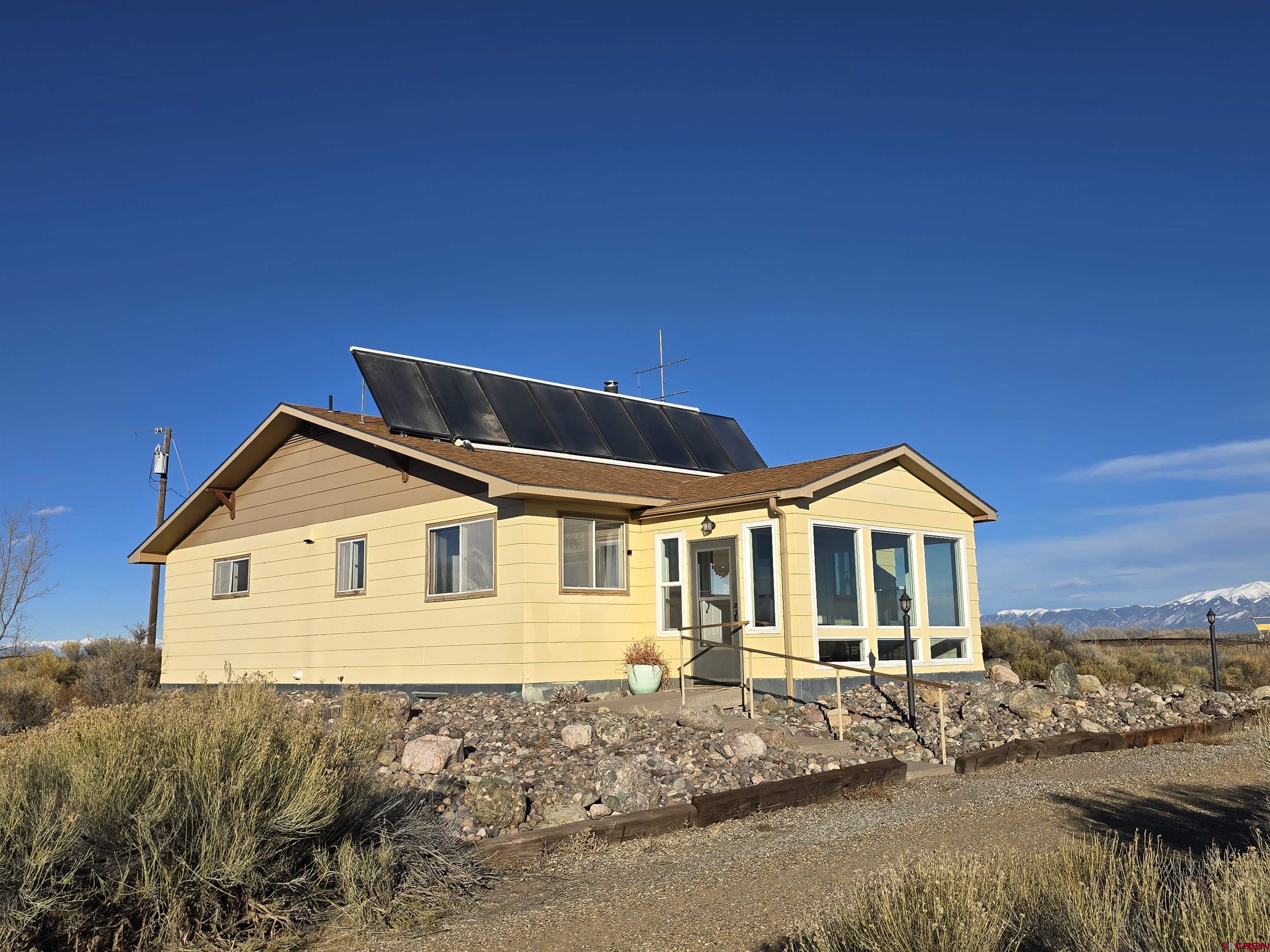 4590 Sierra Vista Road Alamosa, CO 81101 - Photo 1 of 31 a front view of a house with a yard