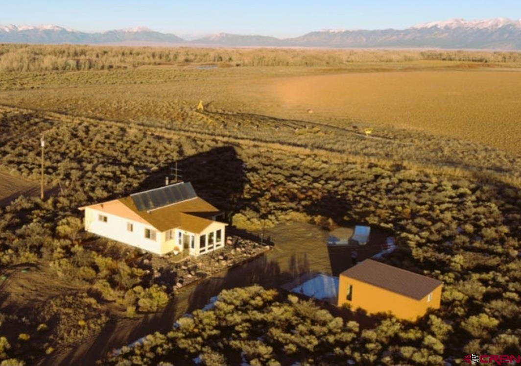 an aerial view of ocean and residential houses with outdoor space