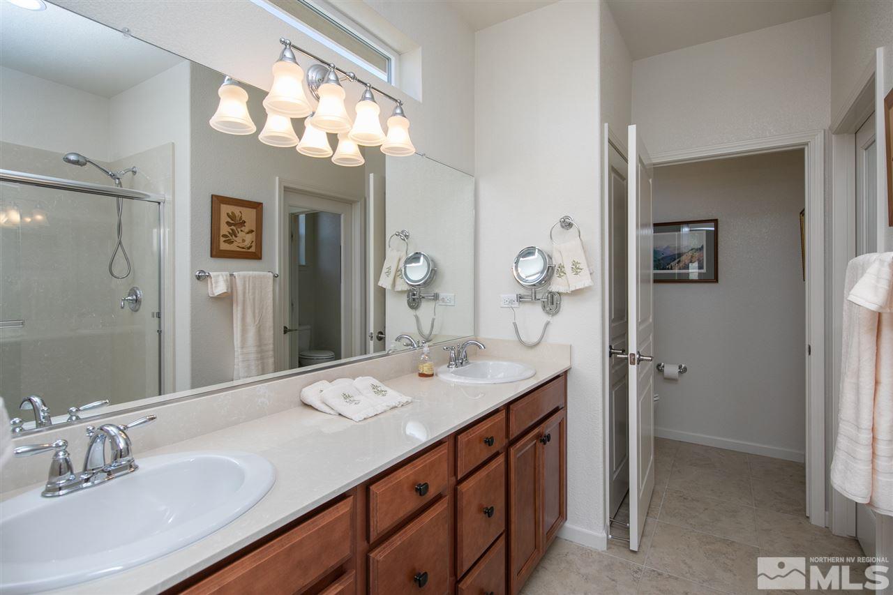 1420 Wakefield Trail Reno, NV 89523 - Photo 11 of 23 a bathroom with a granite countertop sink a large mirror and a shower