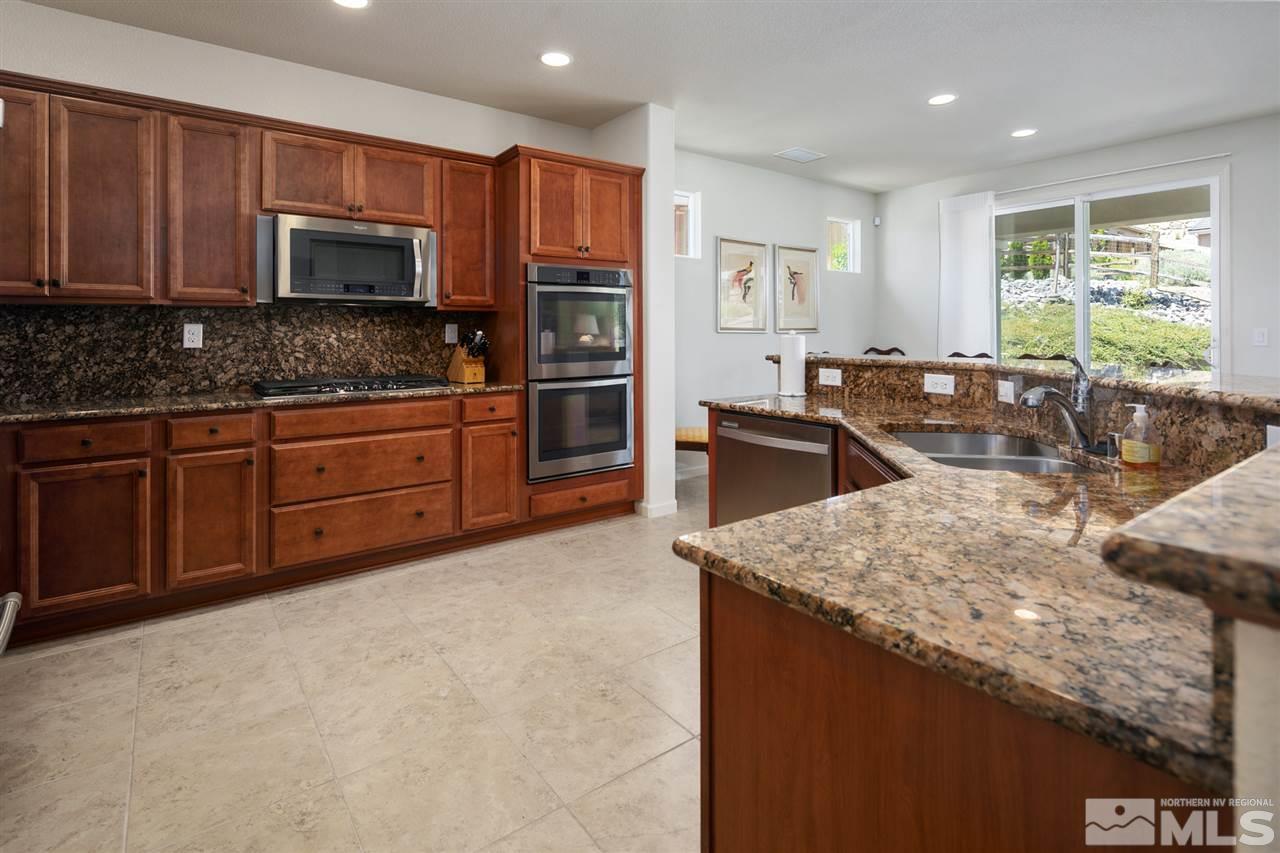 1420 Wakefield Trail Reno, NV 89523 - Photo 7 of 23 a kitchen with stainless steel appliances granite countertop a sink stove and microwave