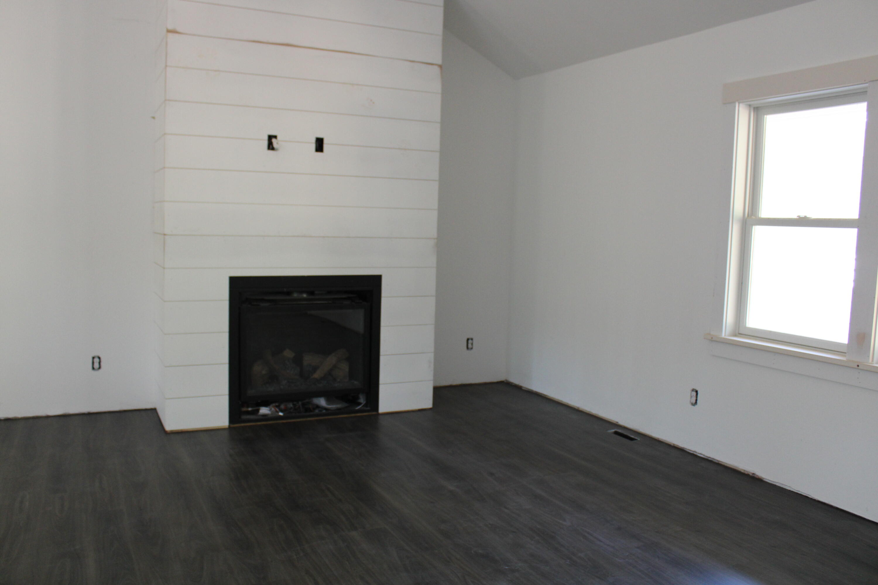 61 Lewis Neck Road East Falmouth, MA 02536 - Photo 4 of 37 an empty room with wooden floor a fireplace and windows