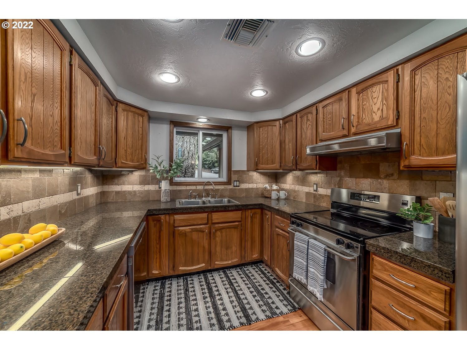 447 Cascade Drive Springfield, OR 97478 - Photo 12 of 32 a kitchen with stainless steel appliances granite countertop wooden cabinets a stove top oven a sink and dishwasher