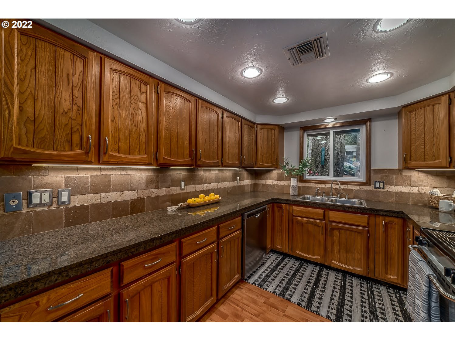447 Cascade Drive Springfield, OR 97478 - Photo 13 of 32 a kitchen with granite countertop wooden cabinets a sink and dishwasher