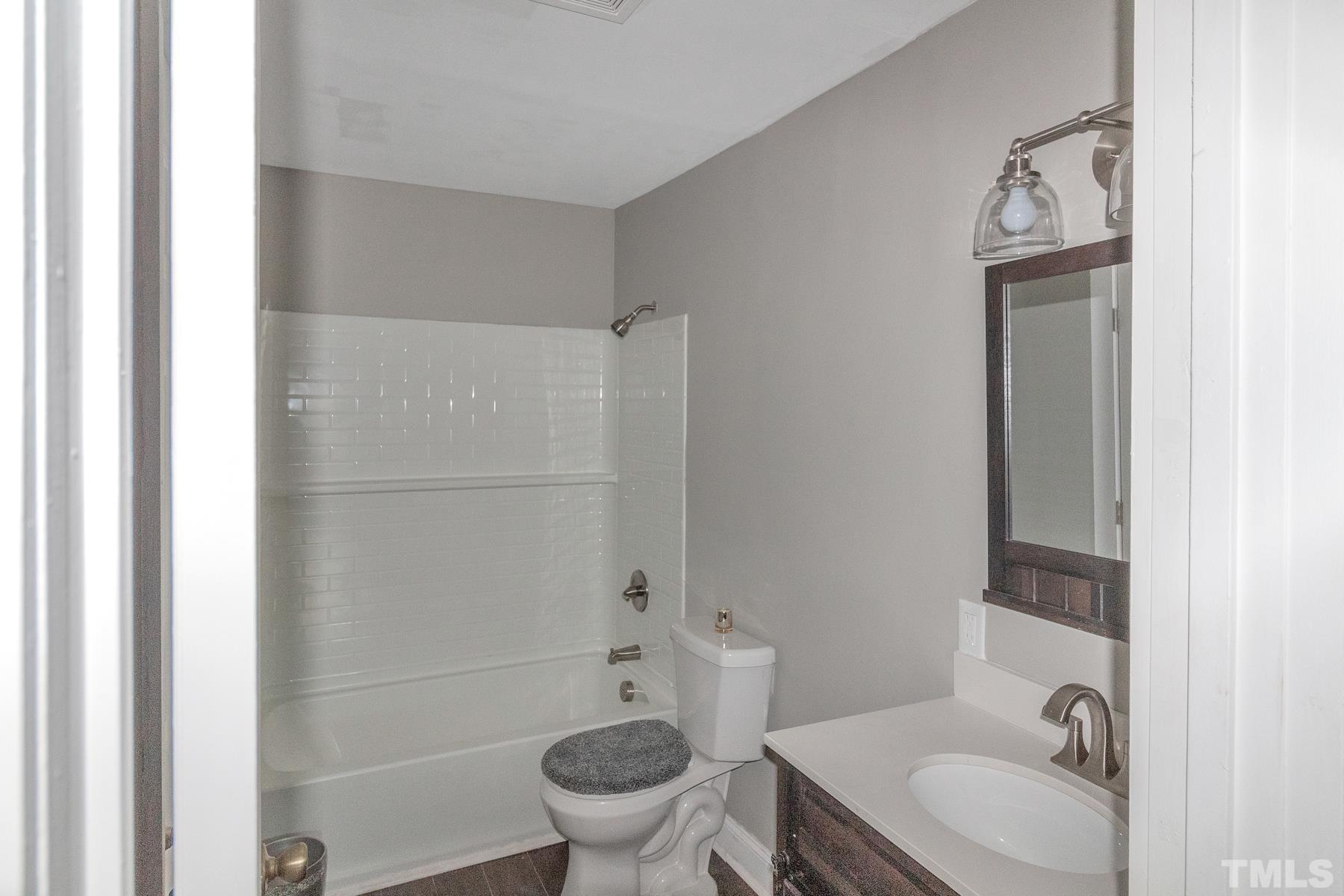 1401 Robinhood Road Durham, NC 27701 - Photo 13 of 14 a bathroom with a granite countertop toilet a sink and mirror