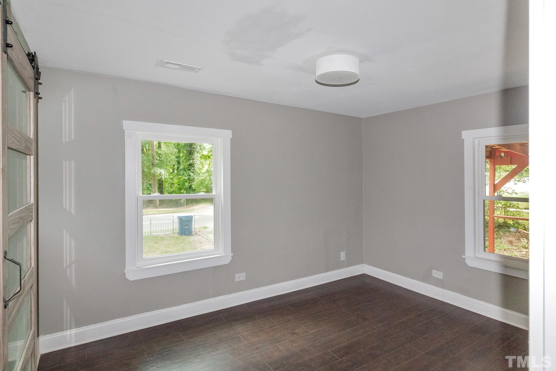 1401 Robinhood Road Durham, NC 27701 - Photo 10 of 14 a view of an empty room with wooden floor and a window
