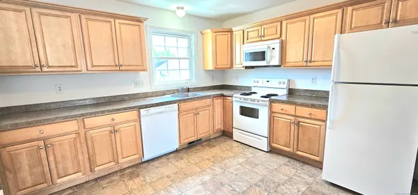 a kitchen with white cabinets white stainless steel appliances and sink