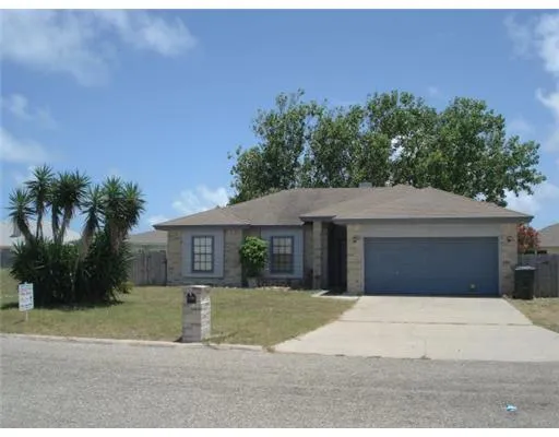a front view of a house with a yard and potted plants