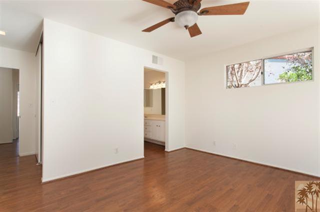70415 Cobb Road Rancho Mirage, CA 92270 - Photo 13 of 23 an empty room with wooden floor ceiling fan and windows