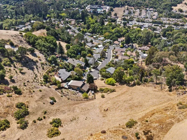 an aerial view of mountain with residential house and space of ocean view