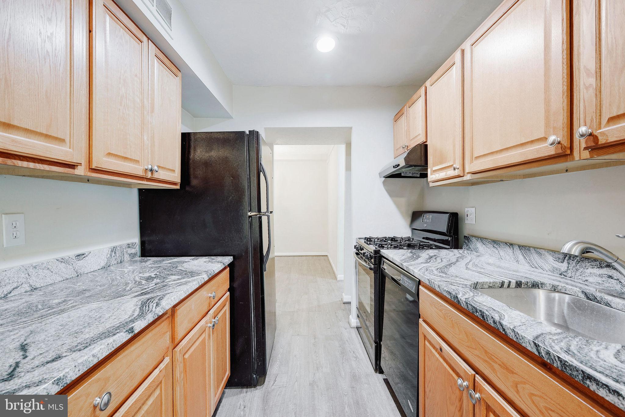 11240 Cherry Hill Road, Unit 18 Beltsville, MD 20705 - Photo 15 of 28 a kitchen with stainless steel appliances granite countertop a sink stove and refrigerator