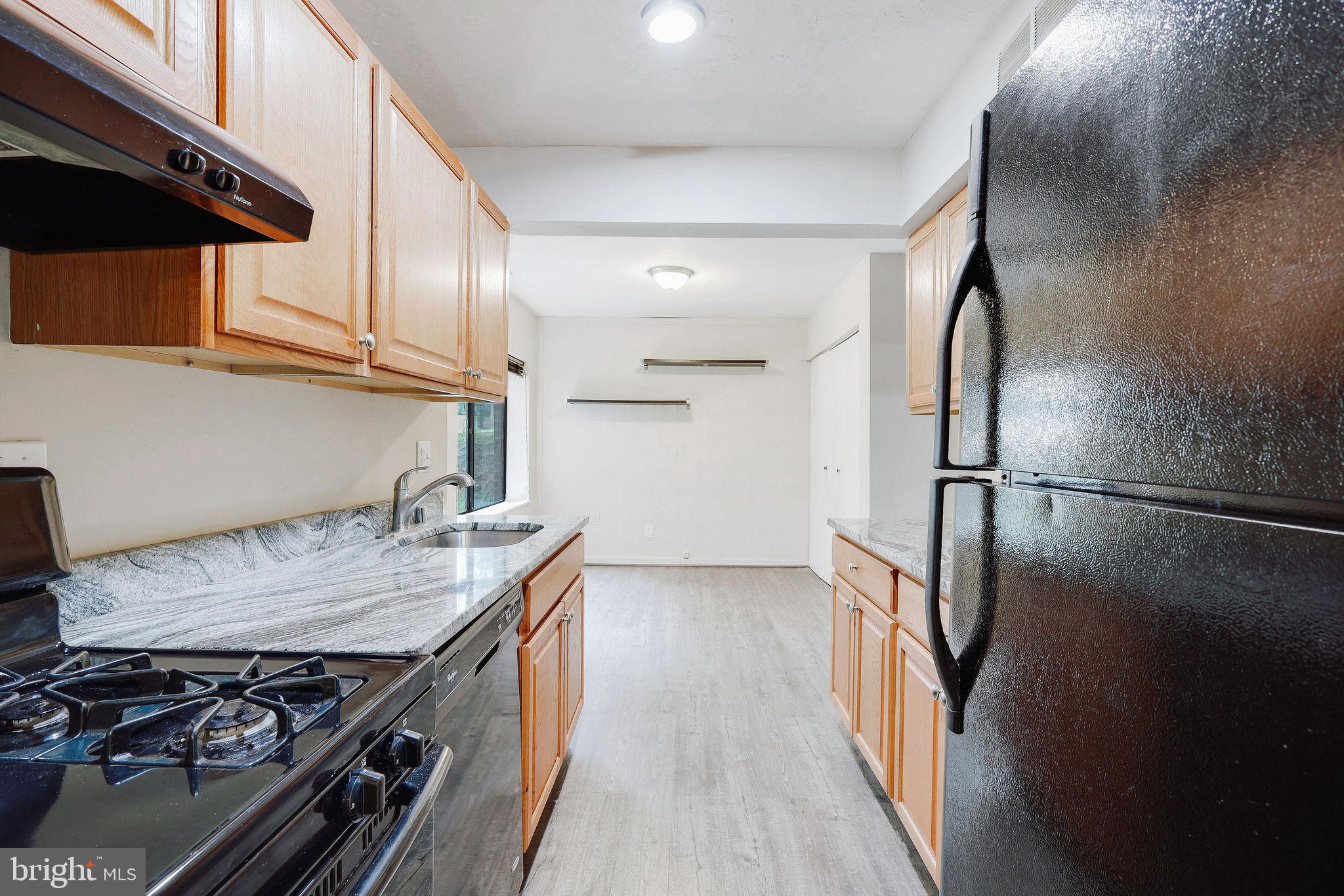 11240 Cherry Hill Road, Unit 18 Beltsville, MD 20705 - Photo 17 of 28 a kitchen with stainless steel appliances granite countertop a refrigerator and a stove