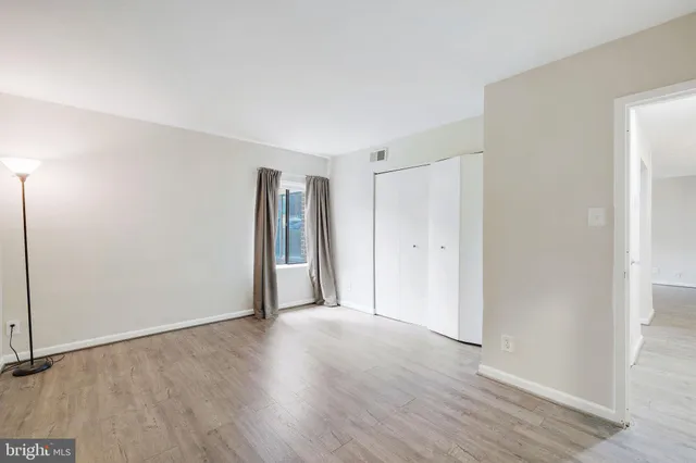 a view of an empty room with wooden floor