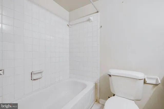 a white toilet sitting next to a bath tub