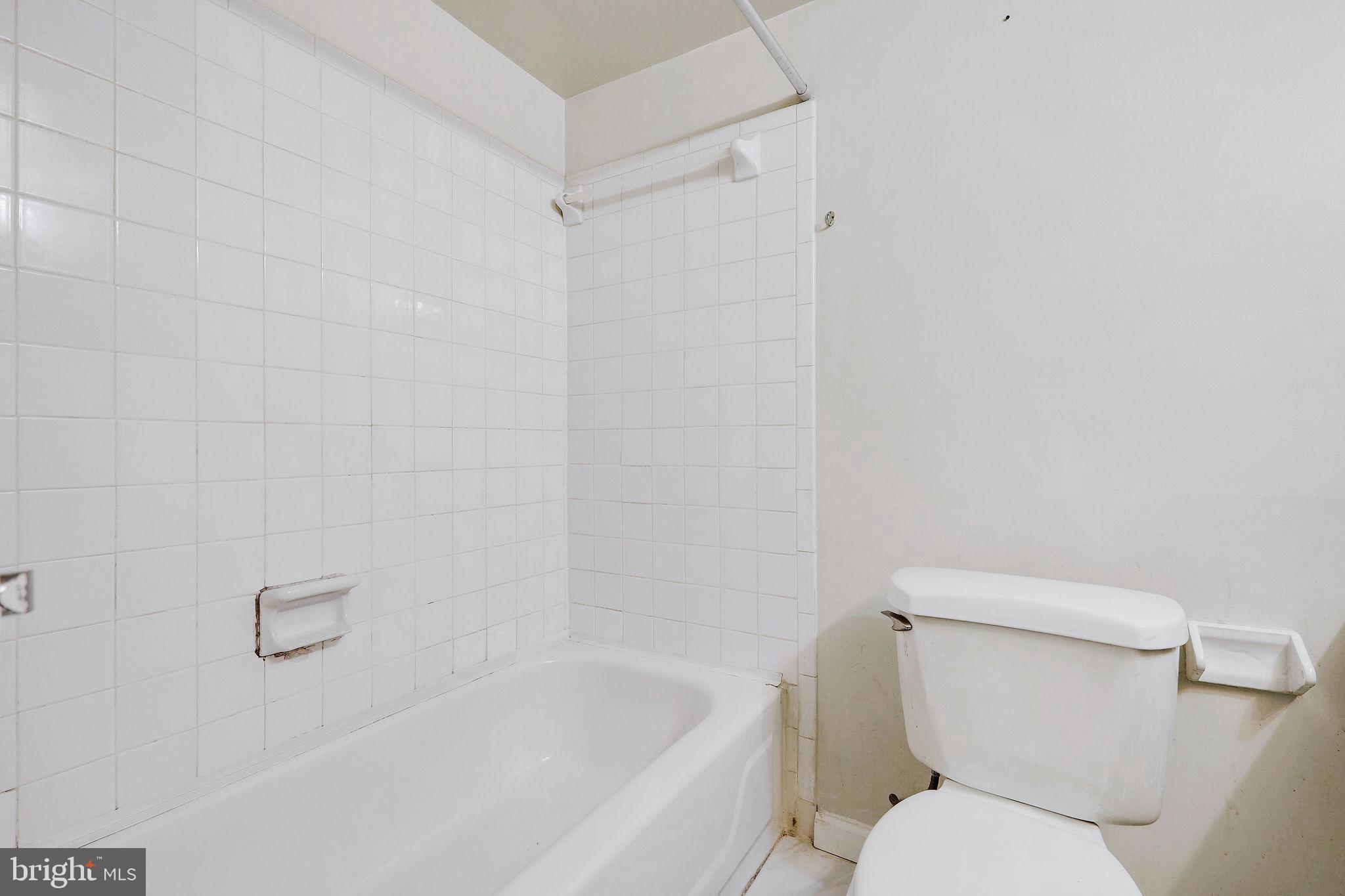 11240 Cherry Hill Road, Unit 18 Beltsville, MD 20705 - Photo 27 of 28 a white toilet sitting next to a bath tub