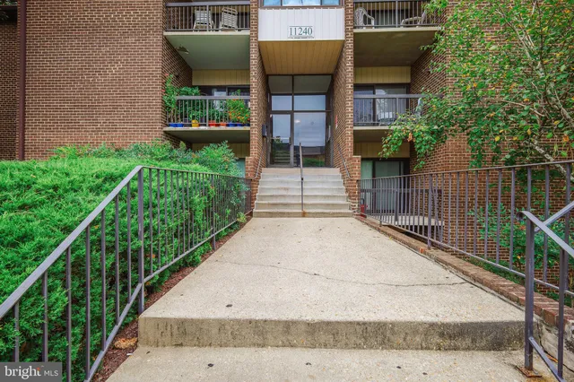 a view of a house with a small yard and wooden fence