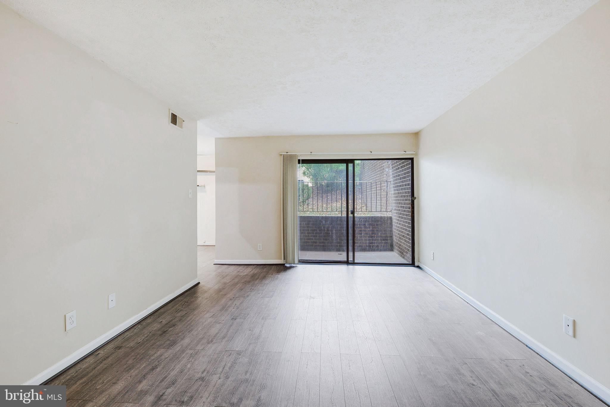 11240 Cherry Hill Road, Unit 18 Beltsville, MD 20705 - Photo 10 of 28 an empty room with wooden floor and windows