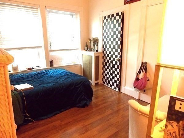 514 Harvard Street, Unit 2D Brookline, MA 02446 - Photo 5 of 11 a bedroom with a bed and a window with wooden floor