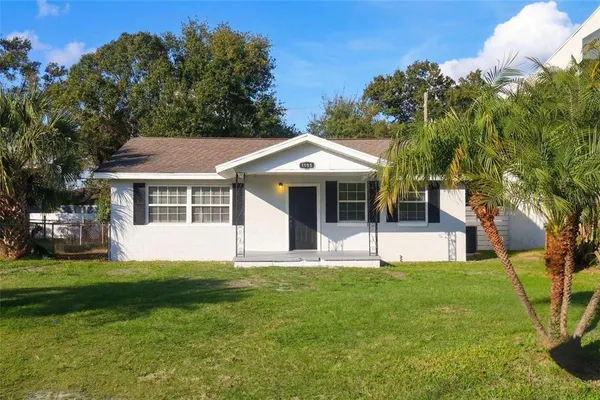 a front view of a house with a yard and trees