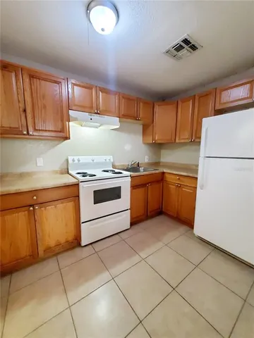 a kitchen with a stove sink and cabinets