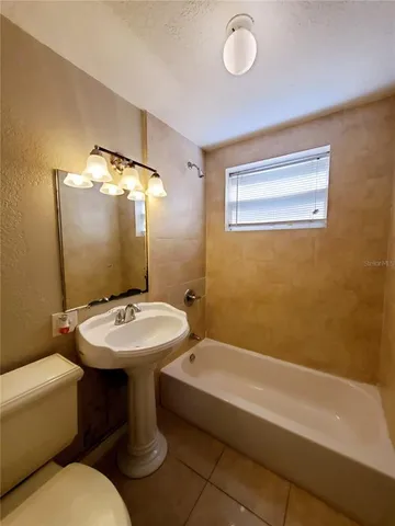 a bathroom with a sink mirror bathtub and toilet