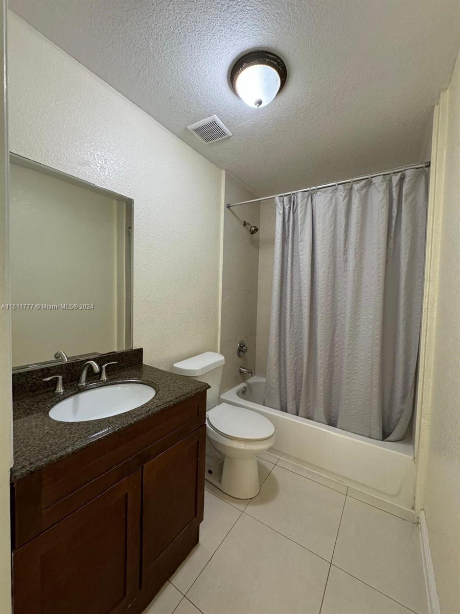 6920 Northwest 4th Avenue, Unit FRONT Miami, FL 33150 - Photo 11 of 13 a bathroom with a double vanity sink toilet and a mirror