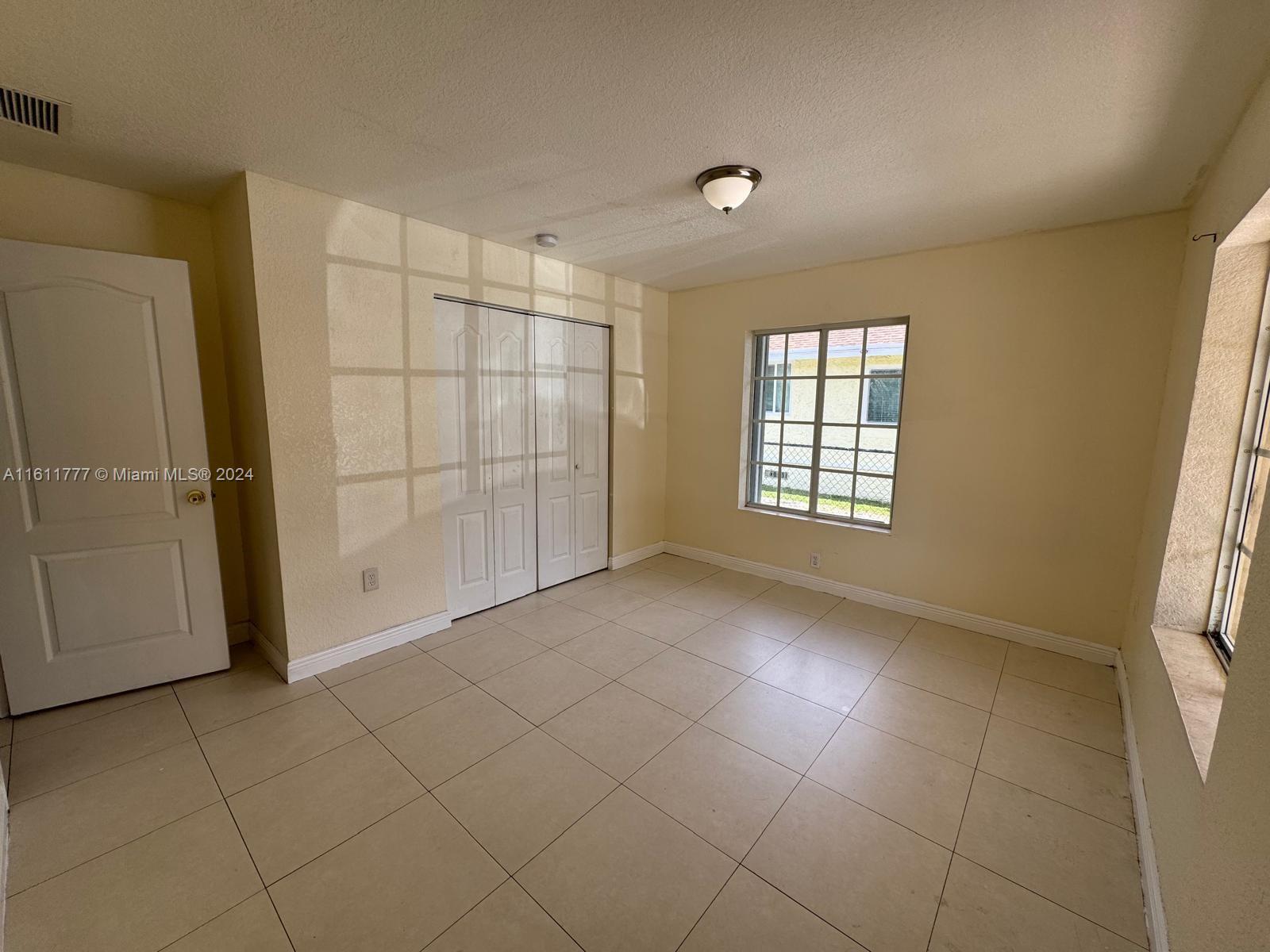6920 Northwest 4th Avenue, Unit FRONT Miami, FL 33150 - Photo 5 of 13 an empty room with windows