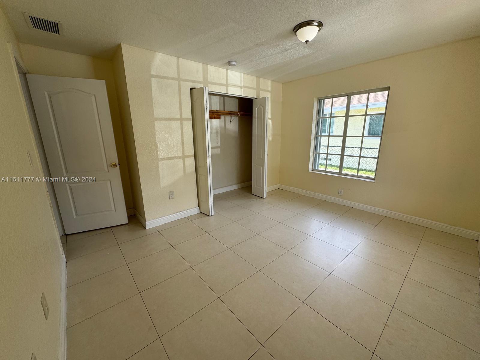 6920 Northwest 4th Avenue, Unit FRONT Miami, FL 33150 - Photo 7 of 13 wooden floor in an empty room with a window
