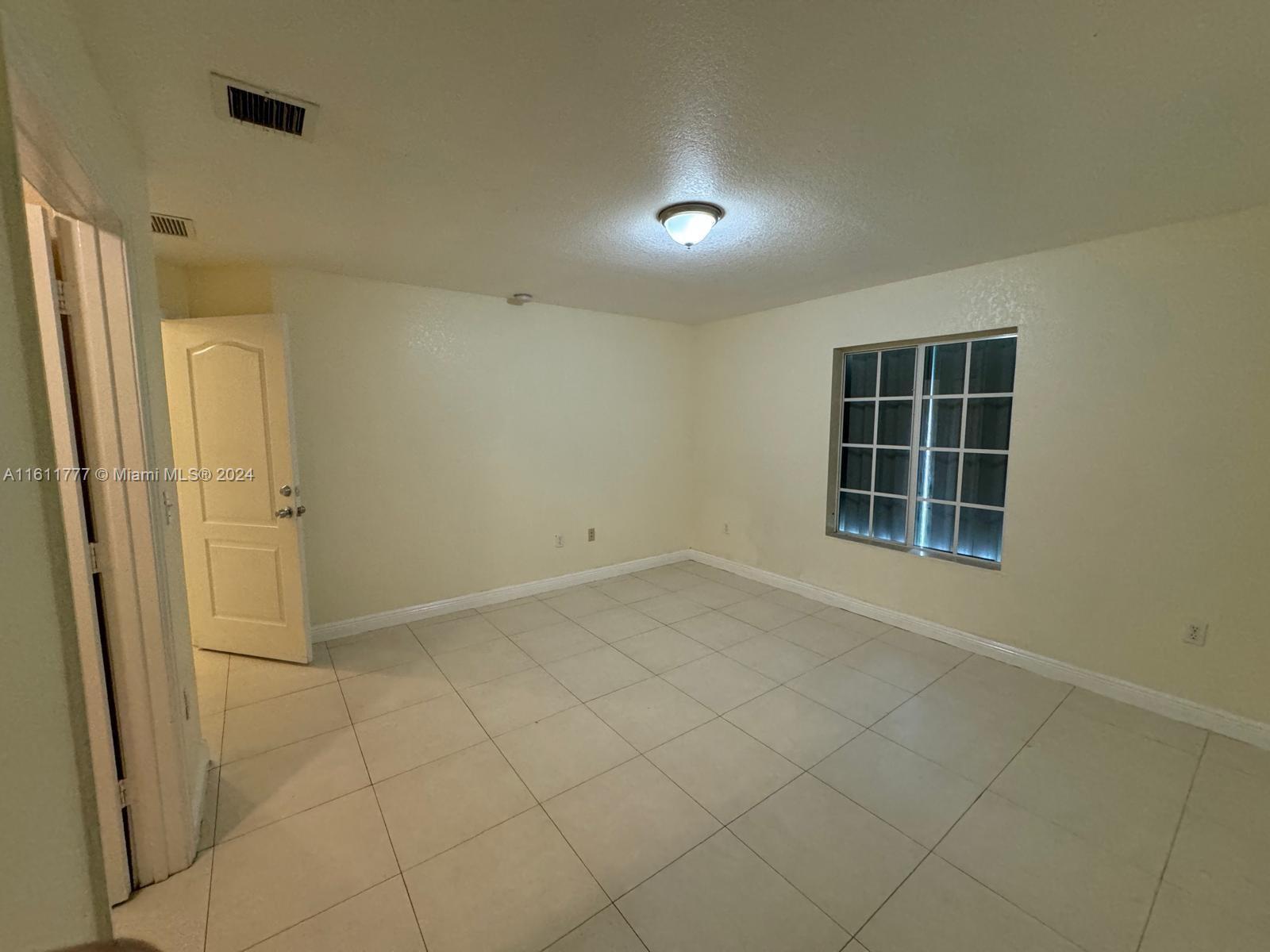 6920 Northwest 4th Avenue, Unit FRONT Miami, FL 33150 - Photo 8 of 13 an empty room with windows