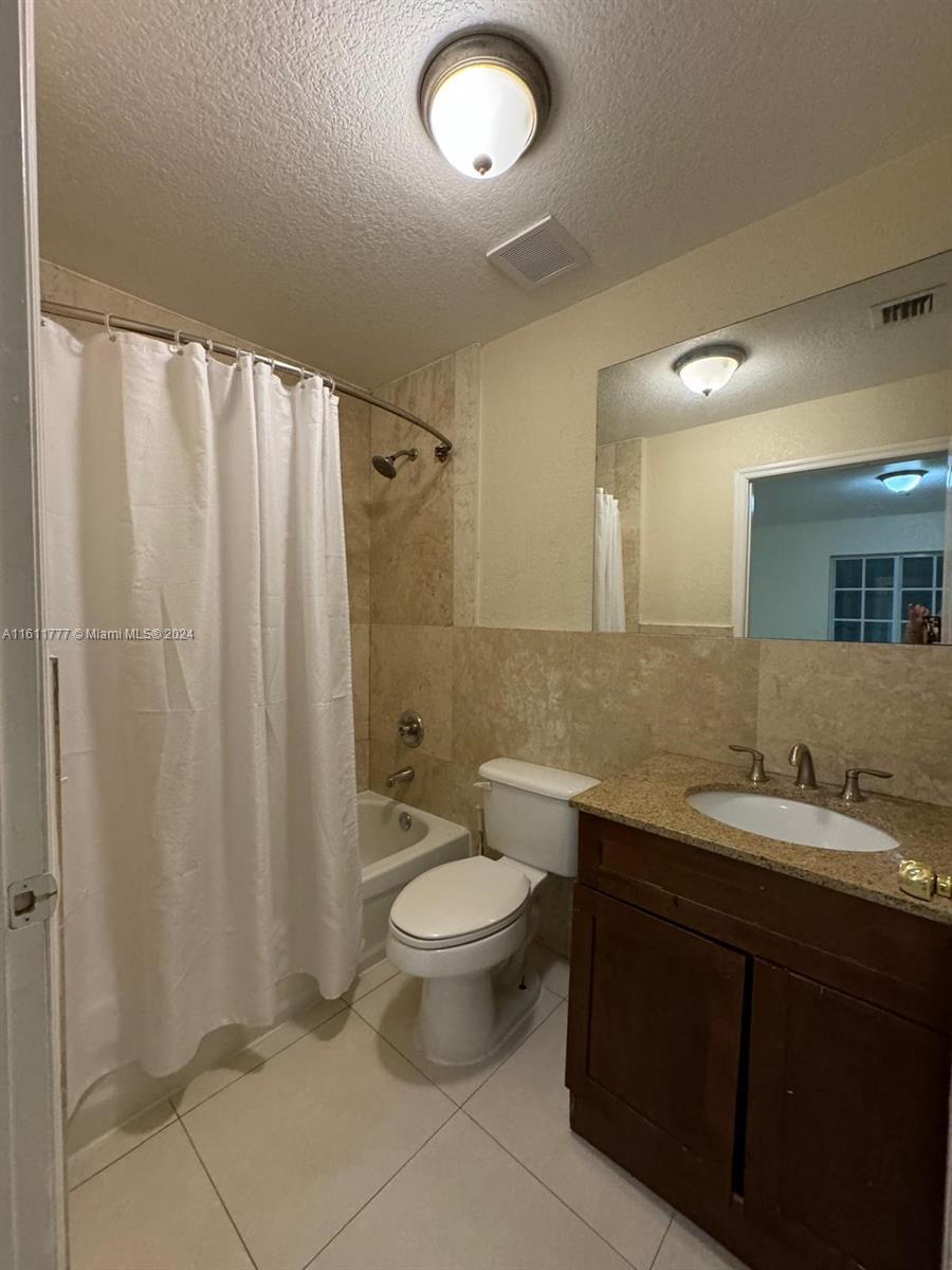 6920 Northwest 4th Avenue, Unit FRONT Miami, FL 33150 - Photo 9 of 13 a bathroom with a double vanity sink toilet and a mirror