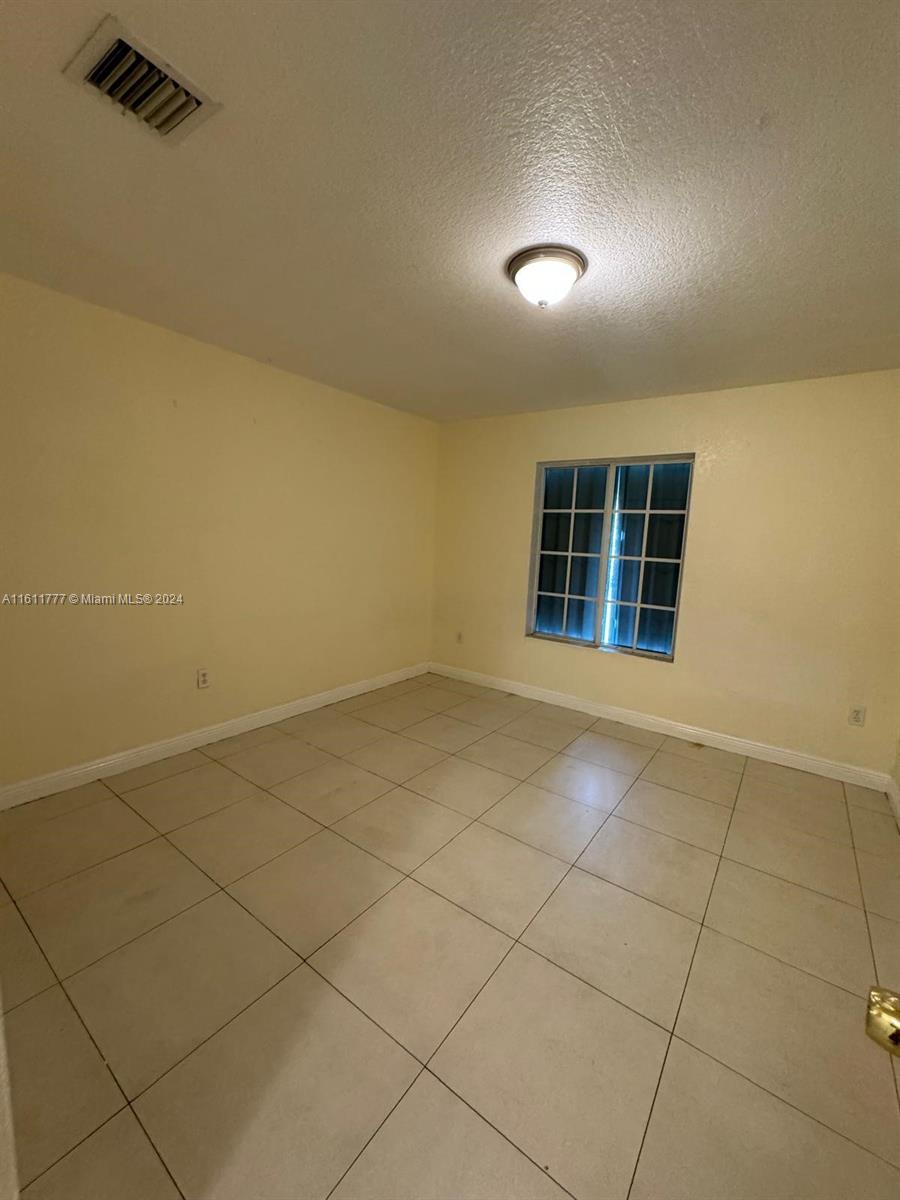 6920 Northwest 4th Avenue, Unit FRONT Miami, FL 33150 - Photo 10 of 13 an empty room with windows