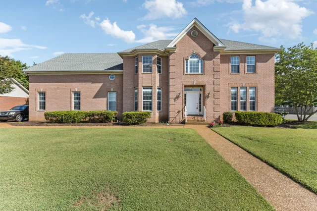 a front view of house with yard and green space