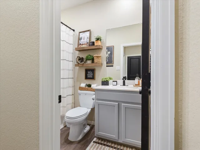 a bathroom with a toilet sink and mirror