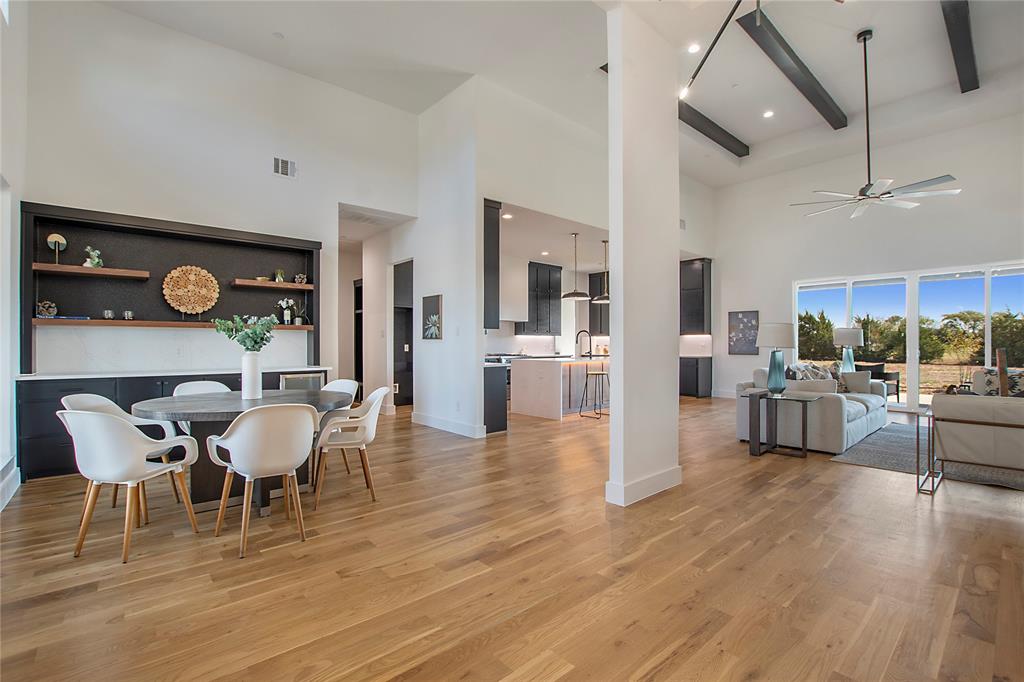 430 Whispering Way Red Oak, TX 75154 - Photo 9 of 40 Spacious open-concept living area featuring high vaulted ceilings with exposed beams, wood-finish flooring, and large windows