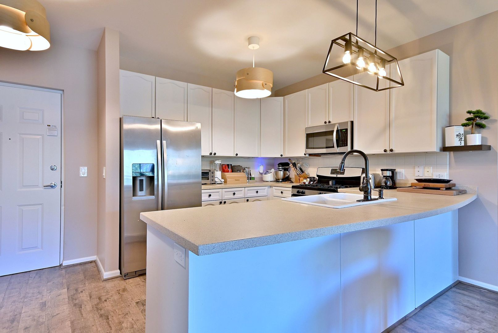 145 South York Street, Unit 404 Elmhurst, IL 60126 - Photo 13 of 28 a large kitchen with stainless steel appliances a stove center island a refrigerator and cabinets