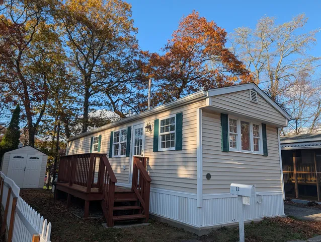 a view of a house with a yard and wooden fence