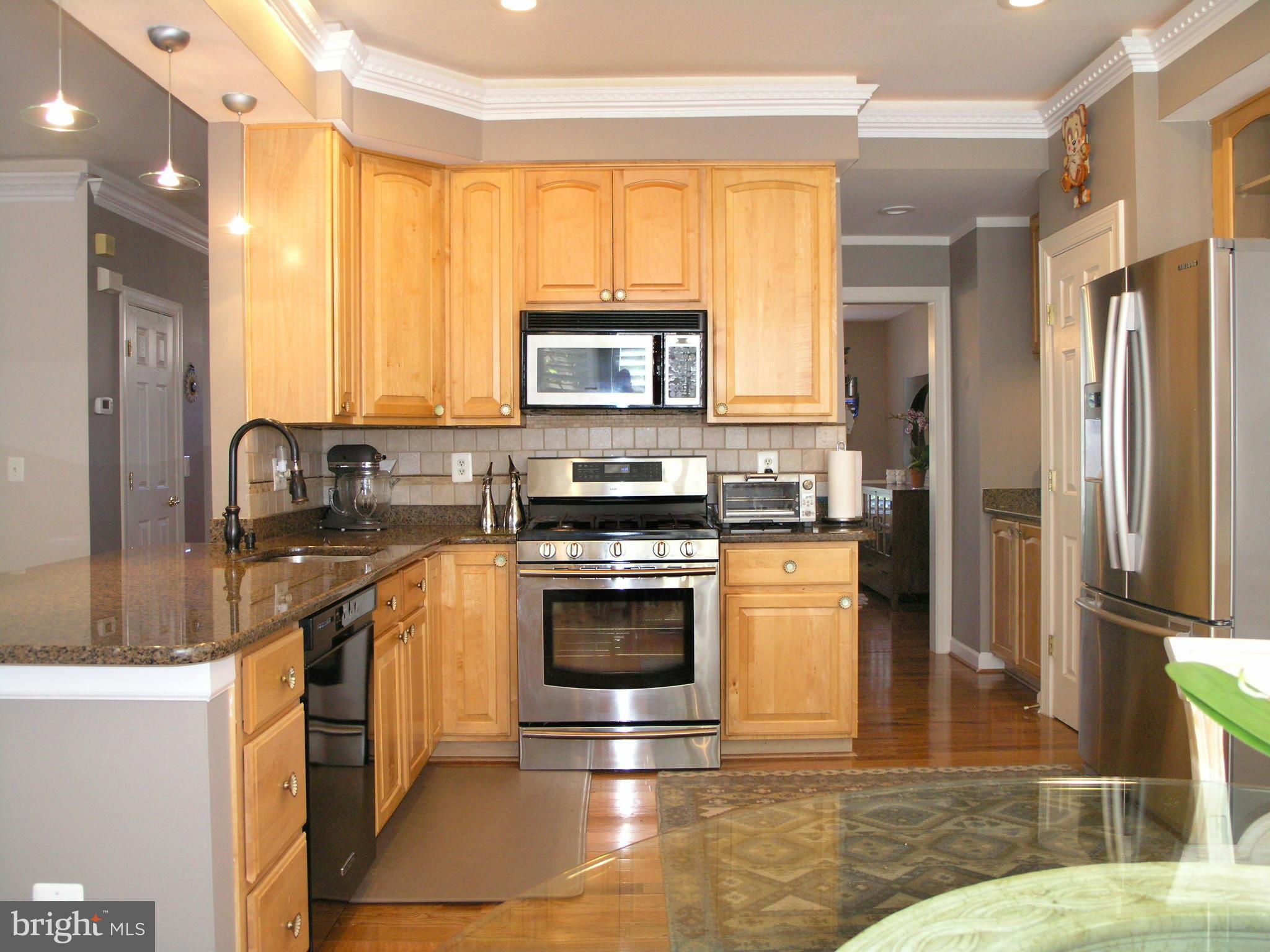 47611 Rhyolite Place Sterling, VA 20165 - Photo 8 of 29 a kitchen with stainless steel appliances granite countertop a stove a sink and a refrigerator