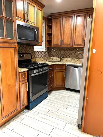 a kitchen with granite countertop a stove sink and microwave